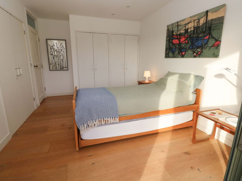 A bedroom with a bed and bedside table at Green Shutters in Freshwater East near Lamphey