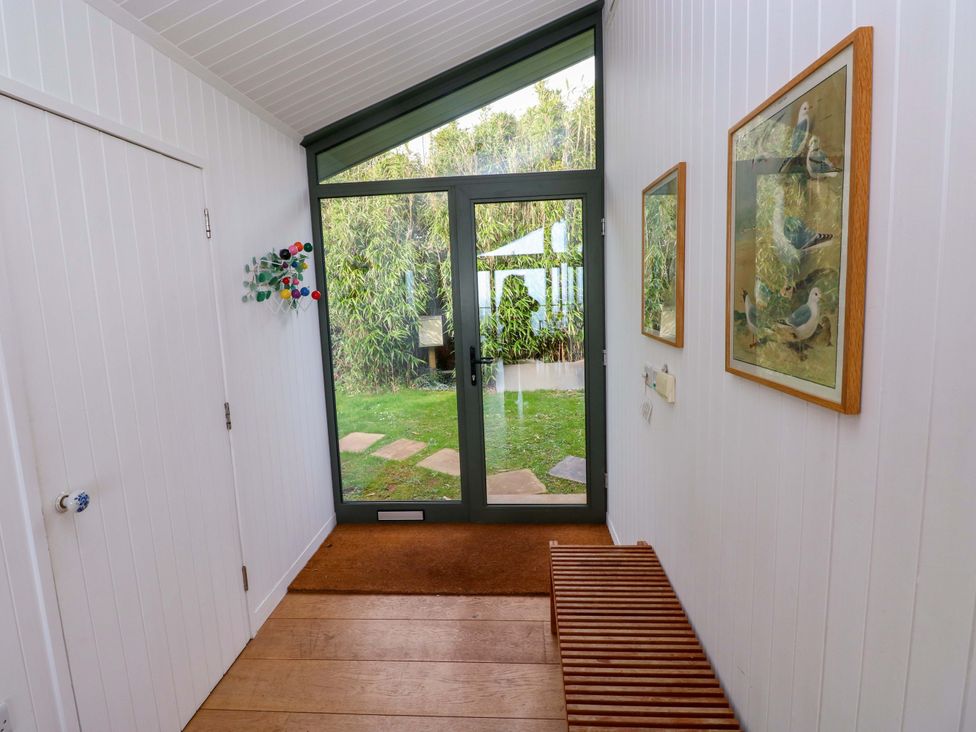 A hallway with a bench and glass door at Green Shutters Freshwater East near Lamphey
