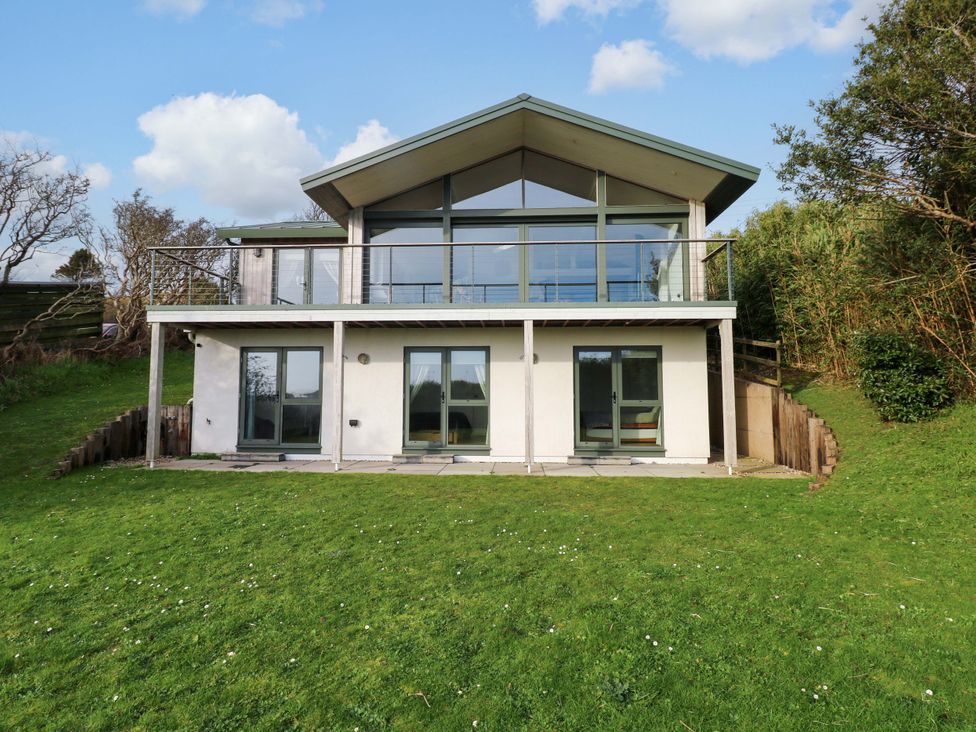 A house with a balcony and large windows at Green Shutters Freshwater East near Lamphey