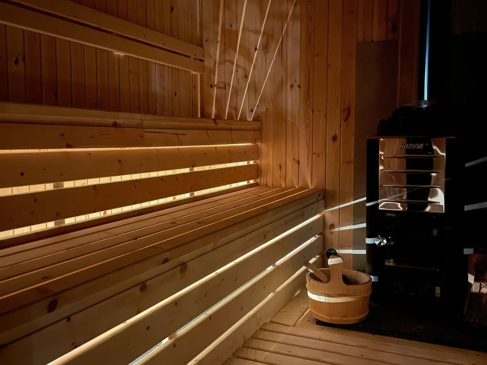A sauna with wooden benches and a heater at Green Shutters in Freshwater East near Lamphey
