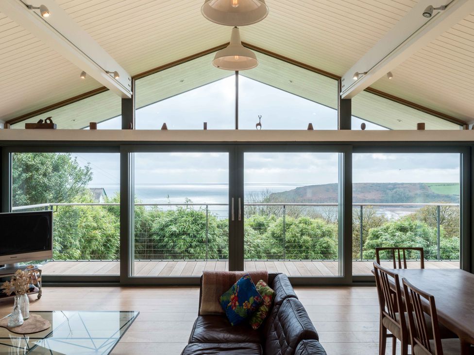 A living room with a sofa and dining table at Green Shutters near Freshwater East