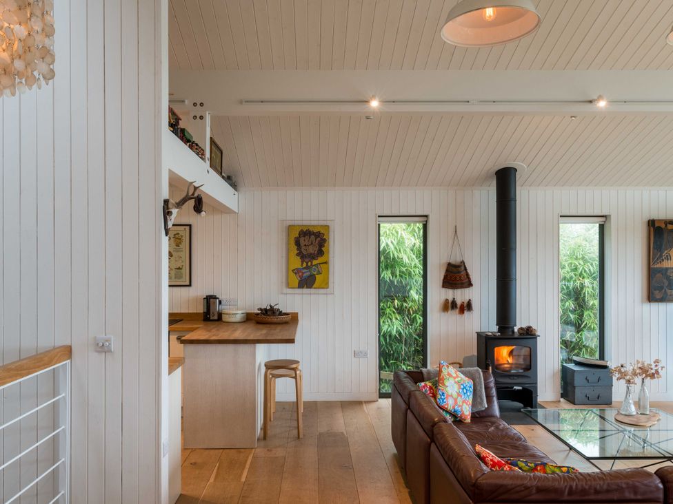 A living room with a coffee table and windows at Green Shutters in Freshwater East near Lamphey