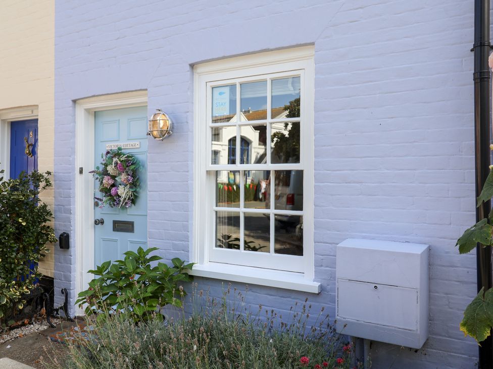A blue door with a wreath and a window at Victoria Cottage in Southwold