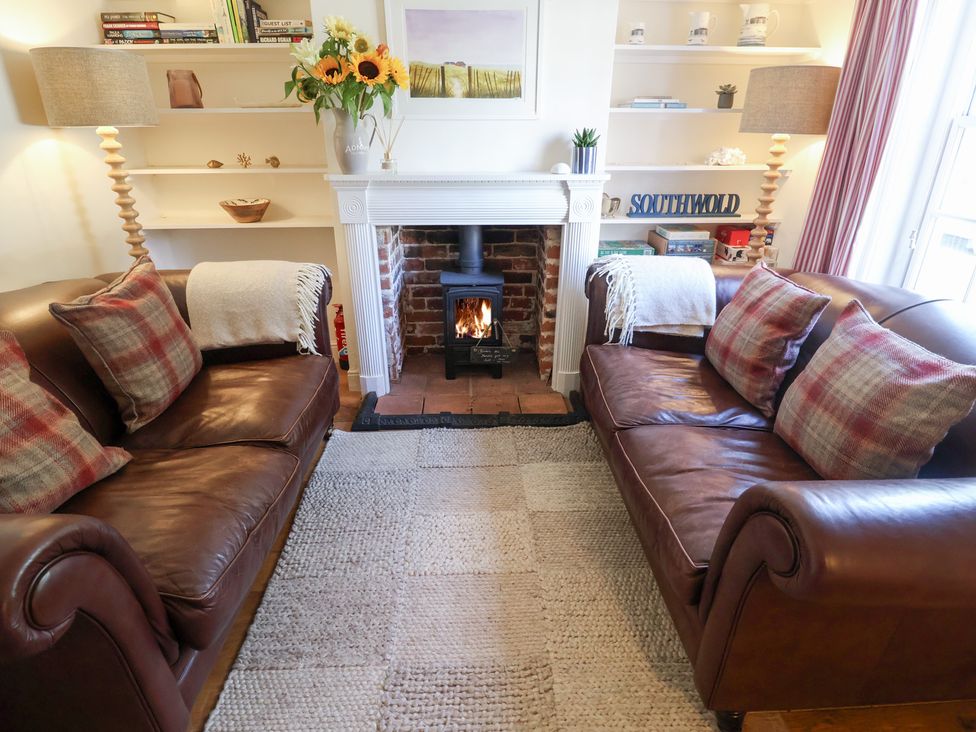 A living room with sofas and a fireplace at Victoria Cottage (4 East Green) Southwold
