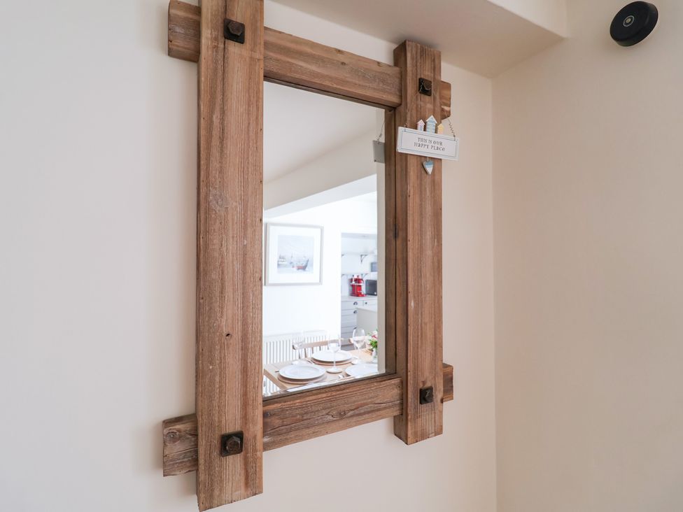 A mirror with a wooden frame in a dining room at Victoria Cottage (4 East Green) Southwold