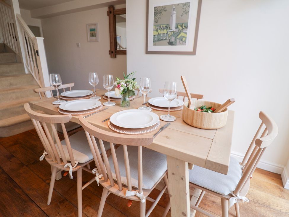 A dining room with a table set for a meal at Victoria Cottage (4 East Green) Southwold