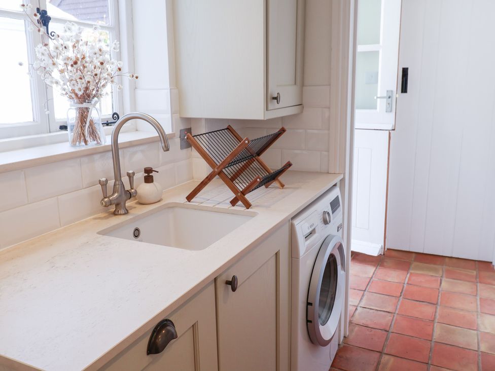 A kitchen with a sink and washing machine at Victoria Cottage (4 East Green) Southwold