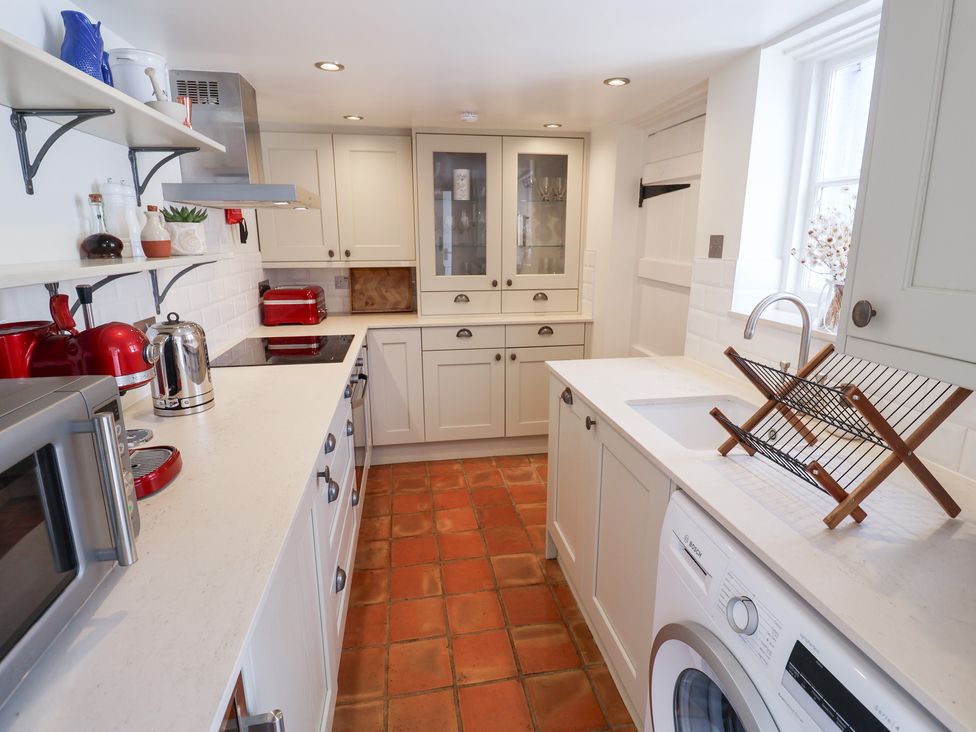 A kitchen with a sink and fridge at Victoria Cottage (4 East Green) Southwold