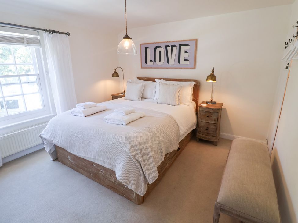 A bedroom with a bed and nightstand at Victoria Cottage (4 East Green) Southwold