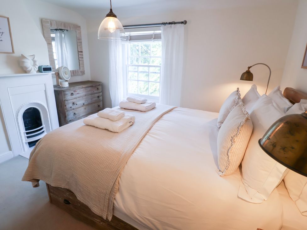 A bedroom with a bed and a dresser at Victoria Cottage (4 East Green) in Southwold