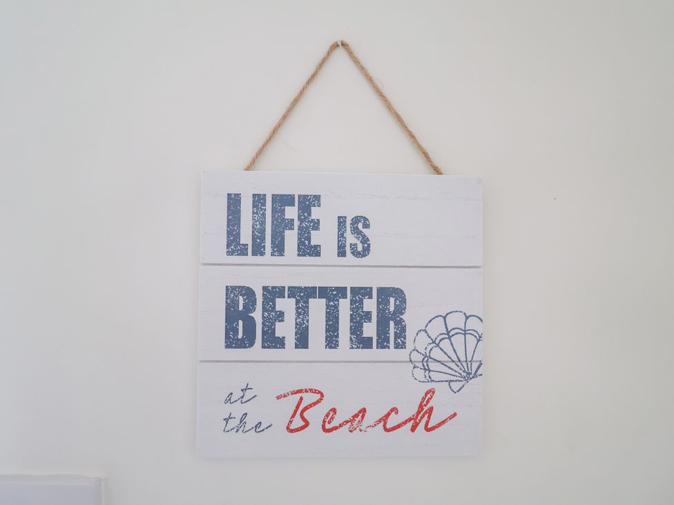 A sign with life is better at the beach displayed on a wall at Victoria Cottage (4 East Green) Southwold