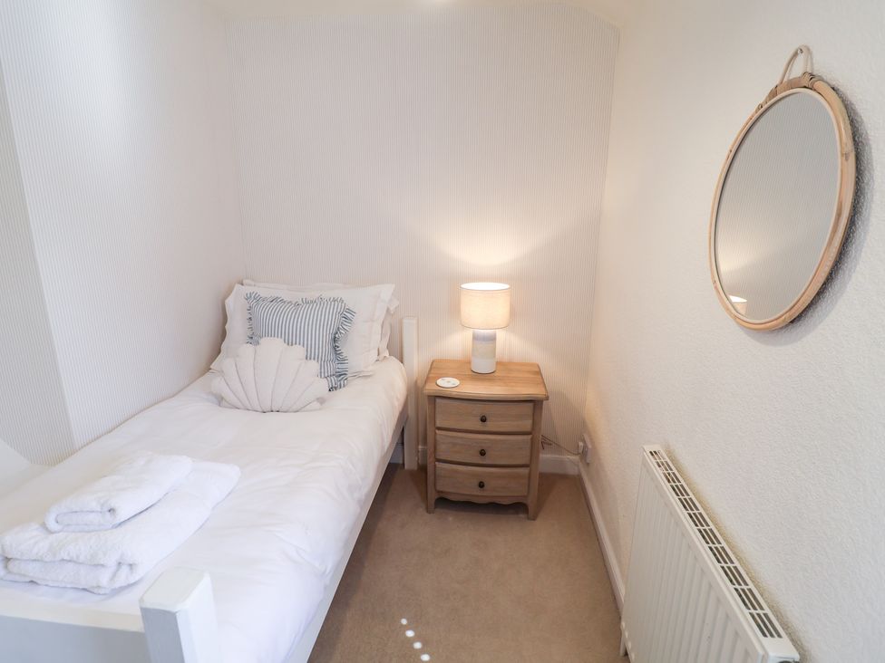 A bedroom with a single bed and bedside table at Victoria Cottage (4 East Green) Southwold