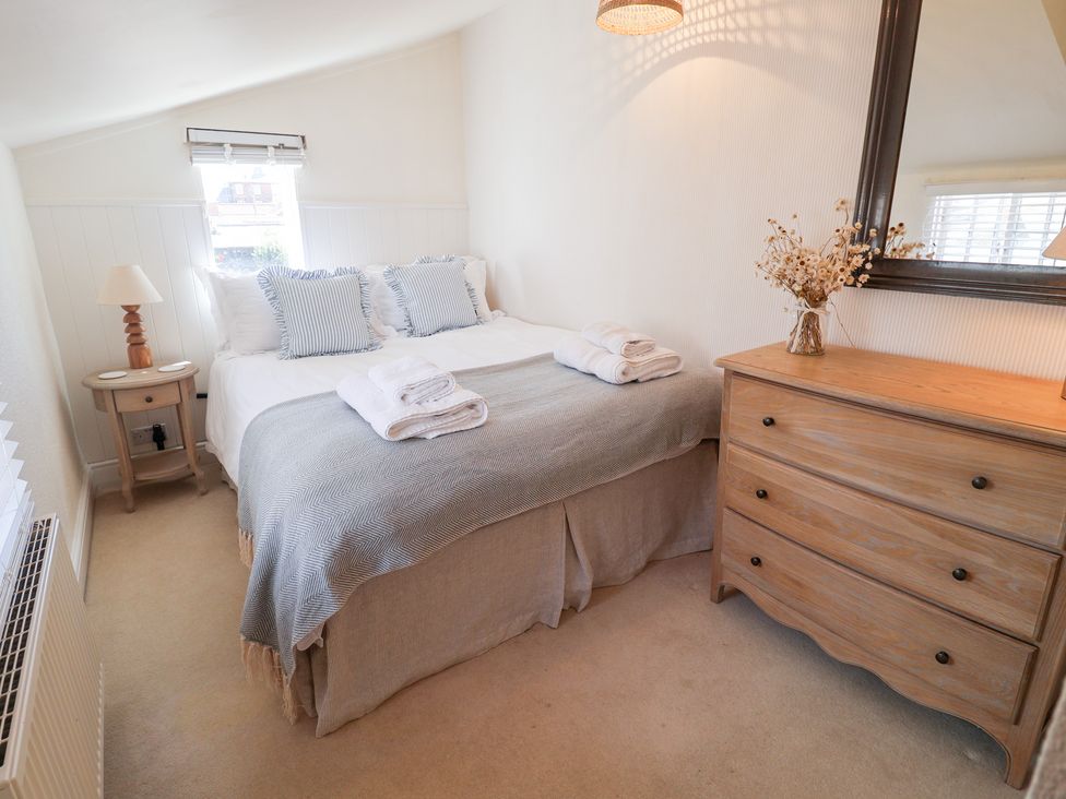 A bedroom with a bed and a dresser at Victoria Cottage (4 East Green) Southwold