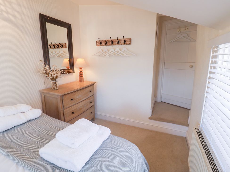 A bedroom with a bed and dressing table at Victoria Cottage (4 East Green) Southwold
