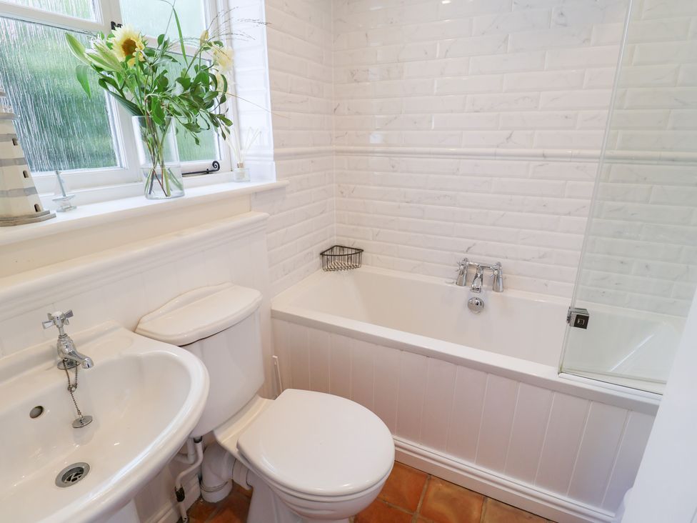A bathroom with a sink, toilet, and bathtub at Victoria Cottage (4 East Green) Southwold