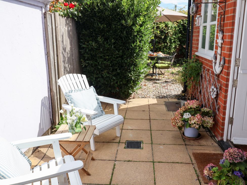 A garden area with chairs and a table at Victoria Cottage (4 East Green) Southwold