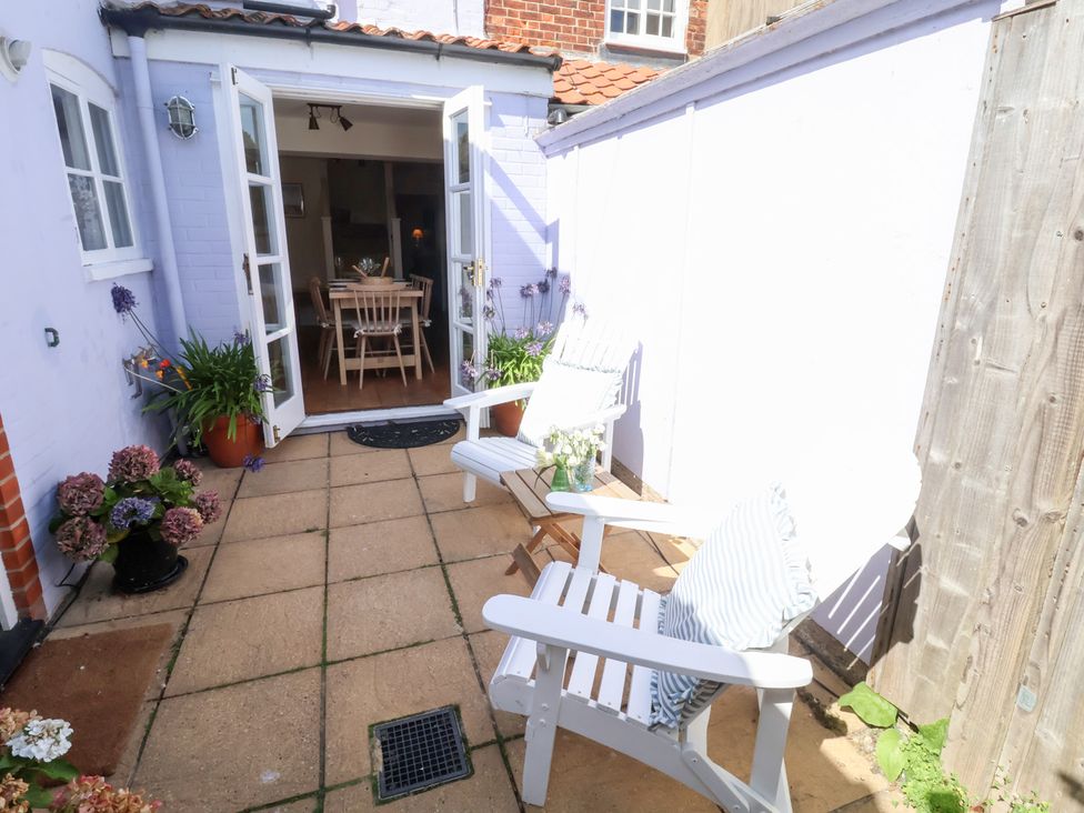 An outdoor space with chairs and a table at Victoria Cottage (4 East Green) Southwold