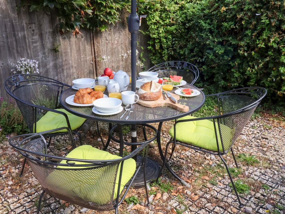 An outdoor dining area with a table set for breakfast at Victoria Cottage (4 East Green) Southwold