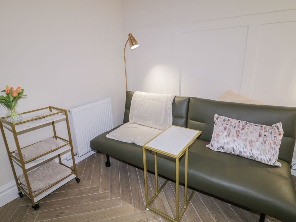 A living room with a sofa and a side table at Church Studio Portstewart