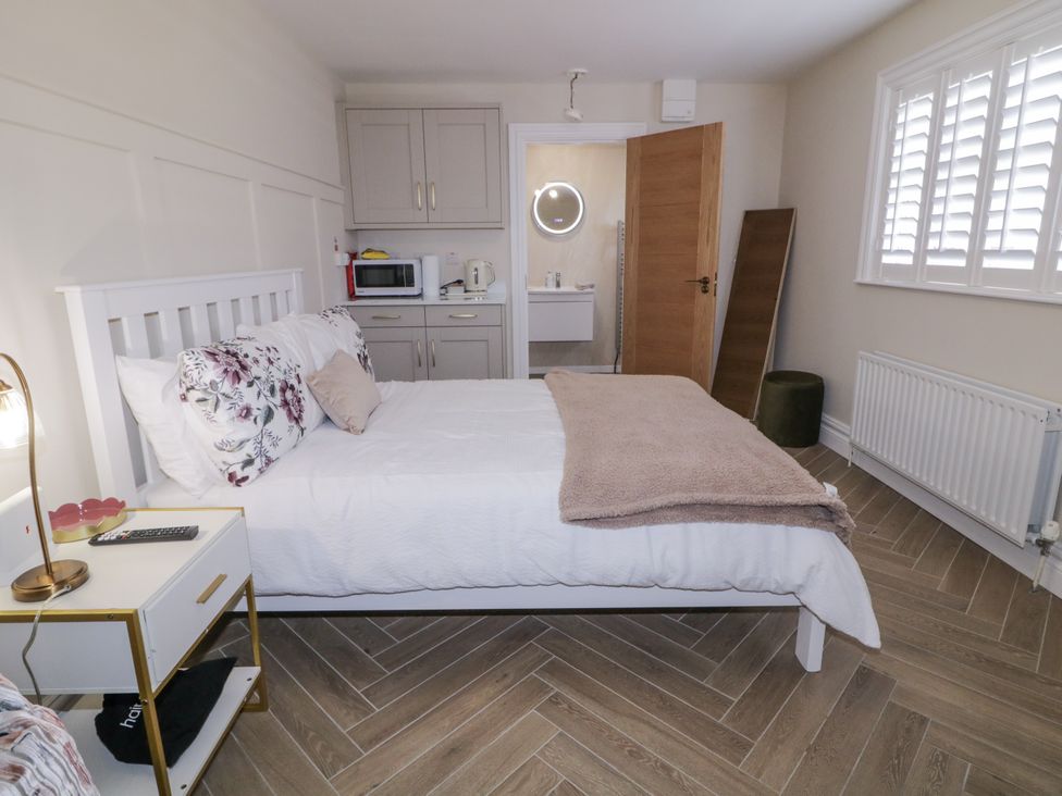 A bedroom with a bed and kitchenette at Church Studio in Portstewart