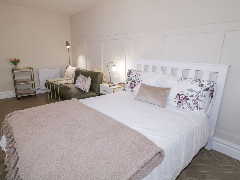 A bedroom with a bed and seating area at Church Studio in Portstewart