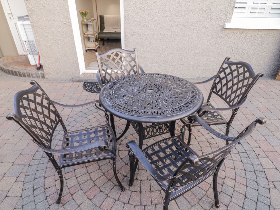 A table with four chairs on a patio at Church Studio in Portstewart