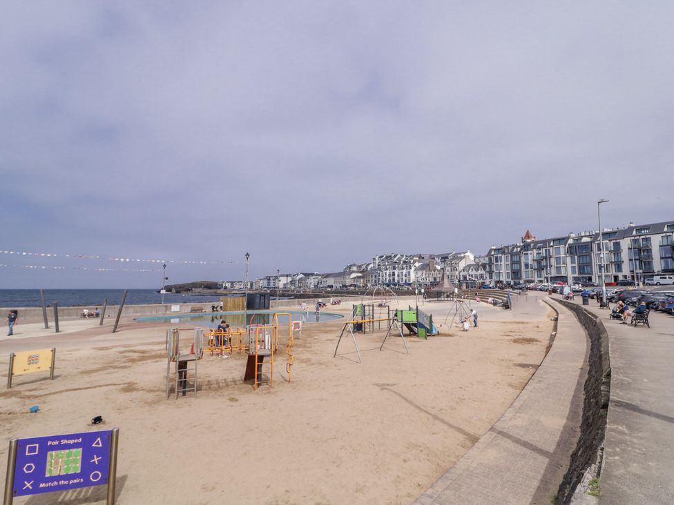 A playground with equipment and beach area near buildings at Church Studio in Portstewart
