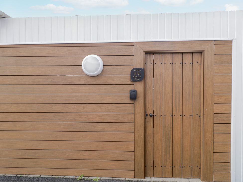 An entrance door with paneling and light fixture at Church Studio in Portstewart, County Londonderry