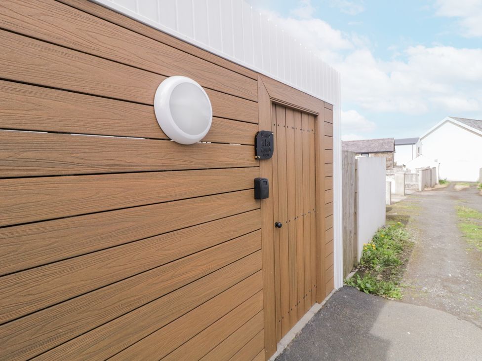 An entrance with a wooden door and light fixture at Church Studio in Portstewart, County Londonderry