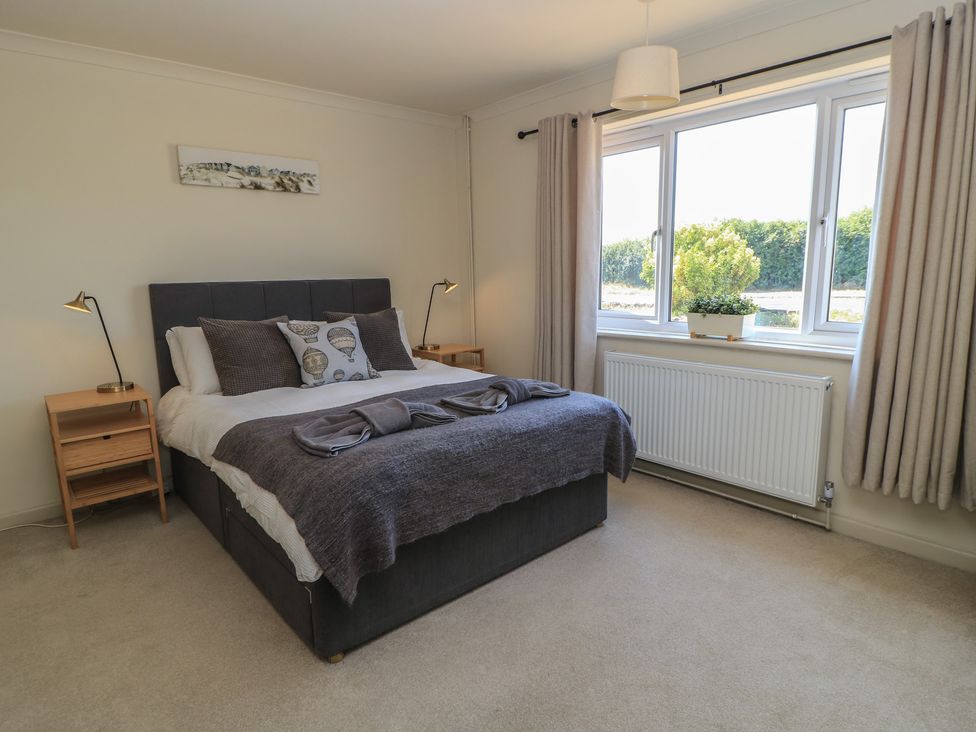 A bedroom with a bed and nightstand at Bayview Cottage Southbourne