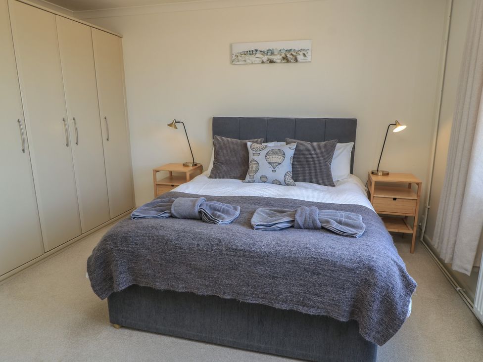 A bedroom with a bed and bedside tables at Bayview Cottage in Southbourne