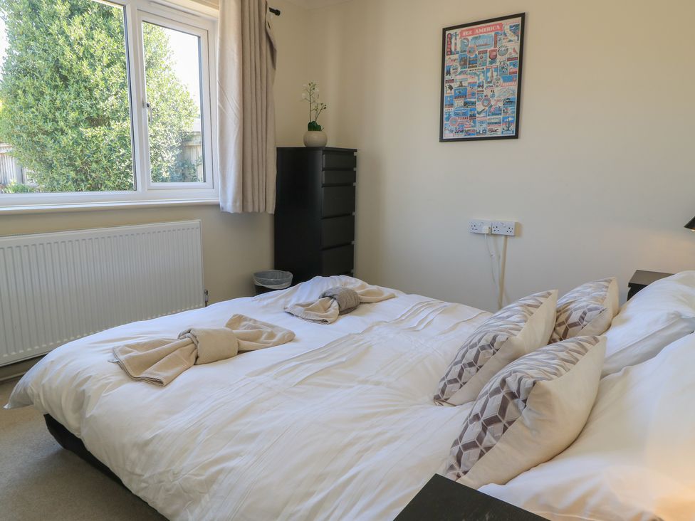 A bedroom with a bed and dresser at Bayview Cottage Southbourne