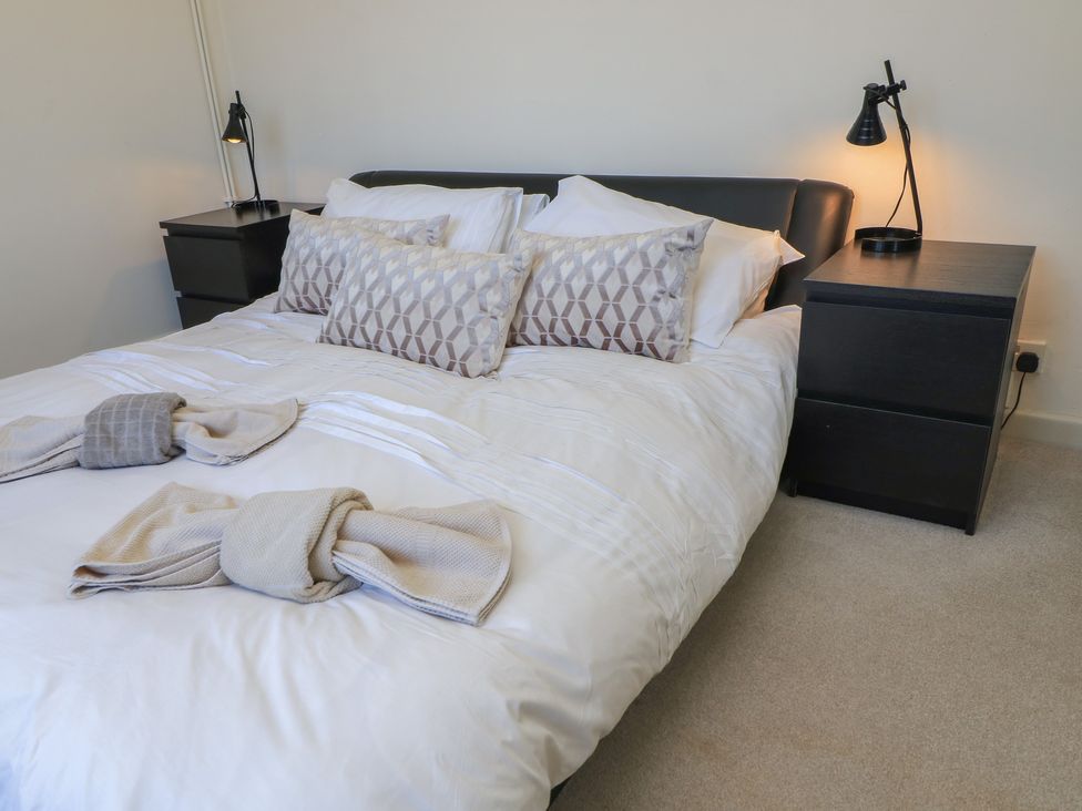 A bedroom with a bed and bedside tables at Bayview Cottage Southbourne
