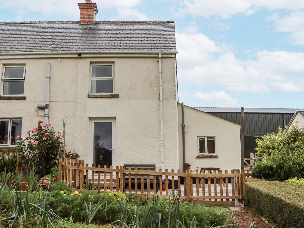 An exterior view of a house with a garden and fence at Aunty Junes Cottage Okehampton