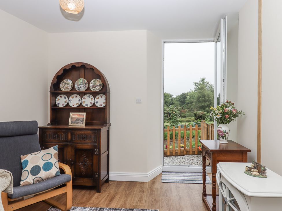 A living room with a sofa and a display cabinet at Aunty Junes Cottage Okehampton
