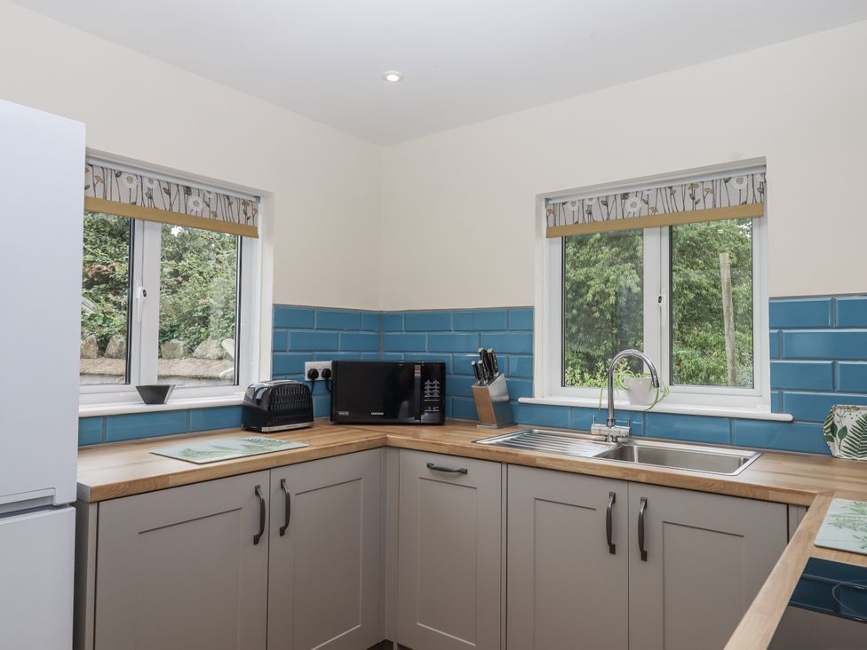 A kitchen with a sink, microwave, and toaster at Aunty Junes Cottage Okehampton