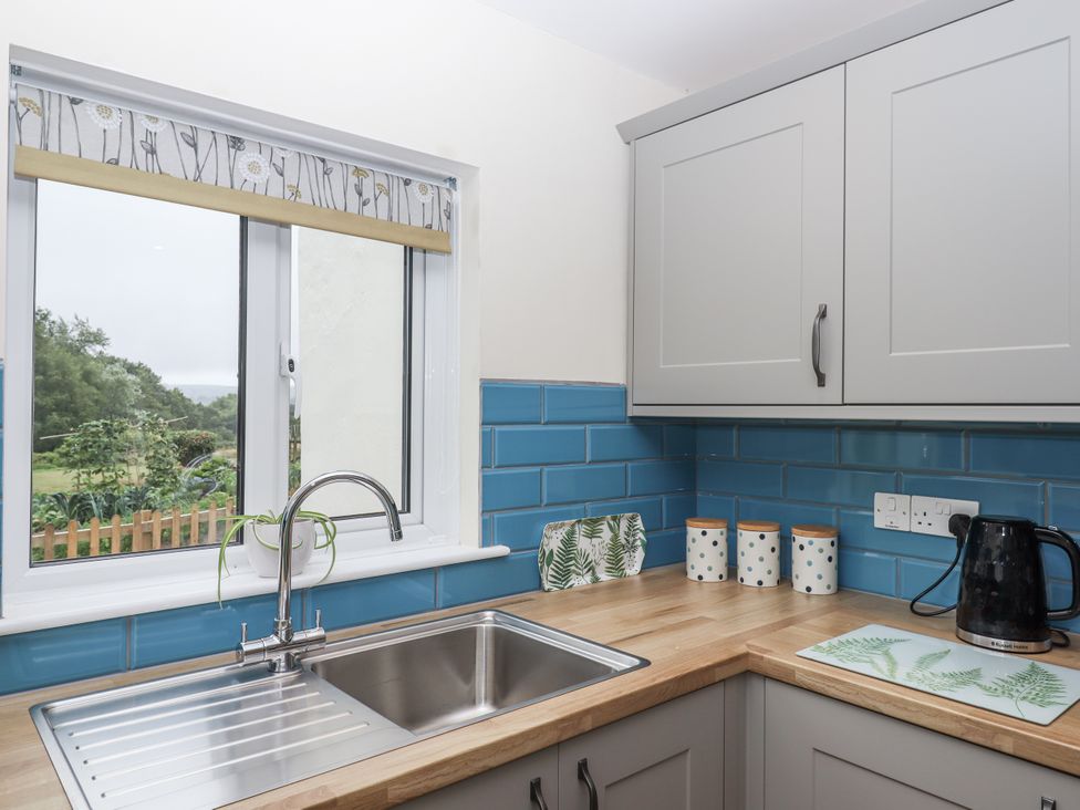 A kitchen with a sink and decorative containers at Aunty Junes Cottage Okehampton