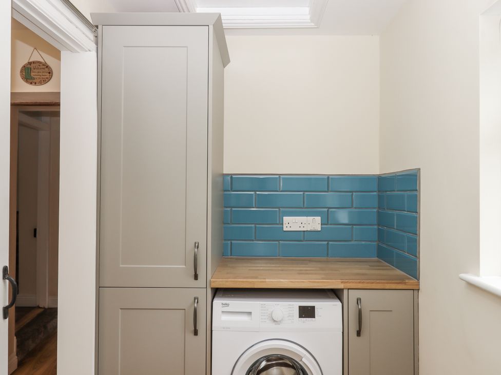 A utility room with a washing machine and cabinet at Aunty Junes Cottage Okehampton