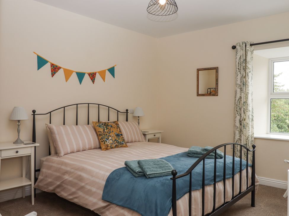 A bedroom with a bed and bedside tables at Aunty Junes Cottage Okehampton