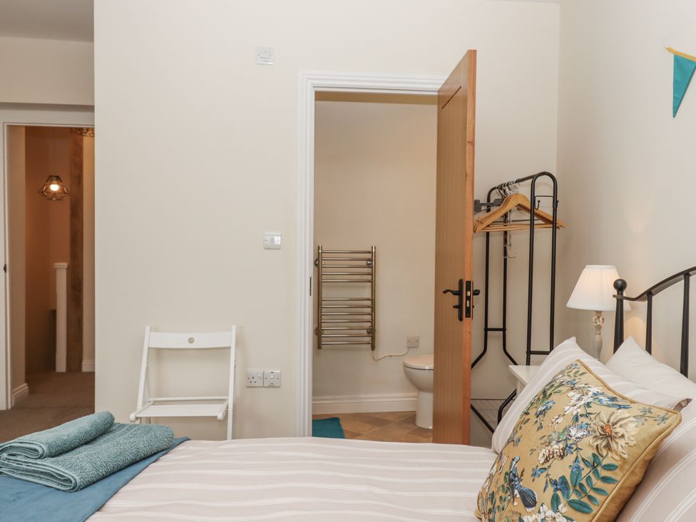 A bedroom with a bed and a door leading to a bathroom at Aunty Junes Cottage Okehampton