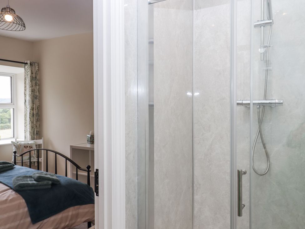 A bedroom with a shower and a bed at Aunty Junes Cottage Okehampton