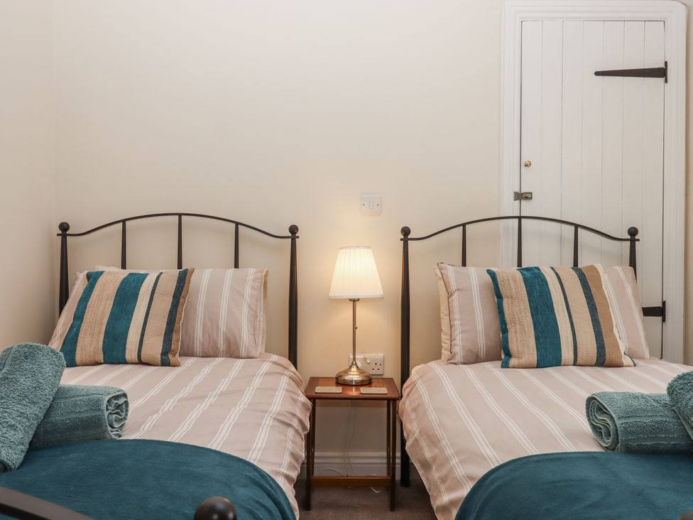 A bedroom with twin beds and a bedside table at Aunty Junes Cottage Okehampton