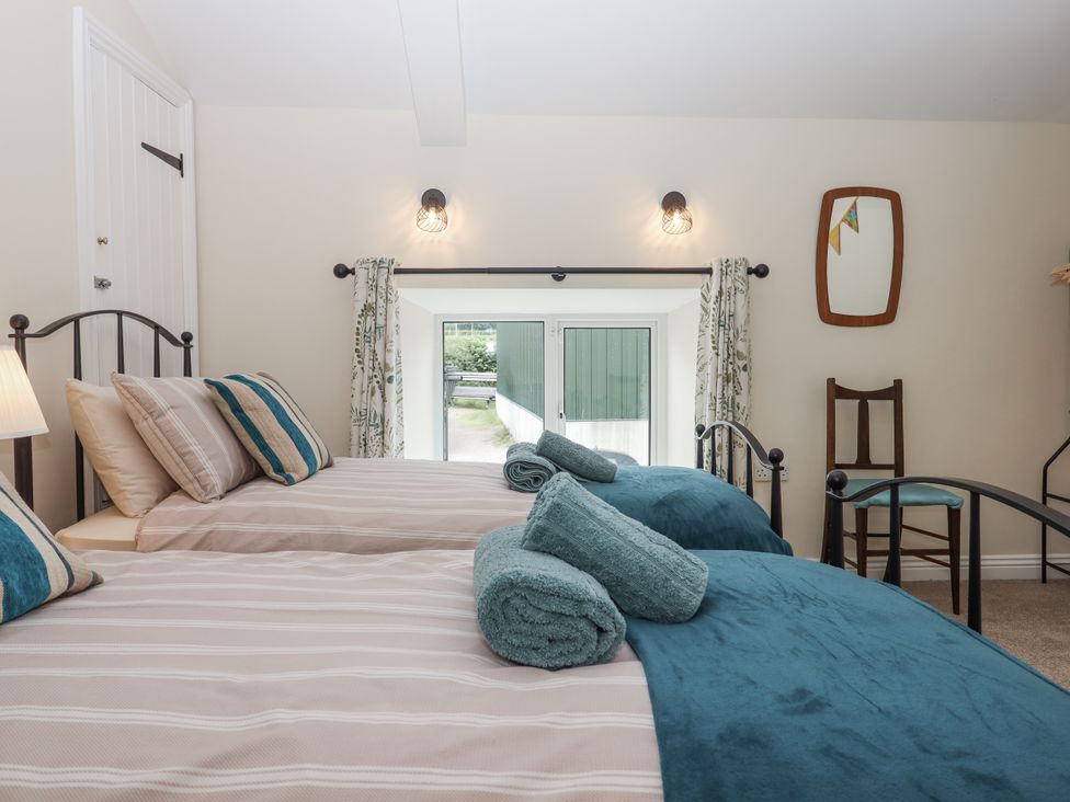 A bedroom with two beds and a window at Aunty Junes Cottage Okehampton