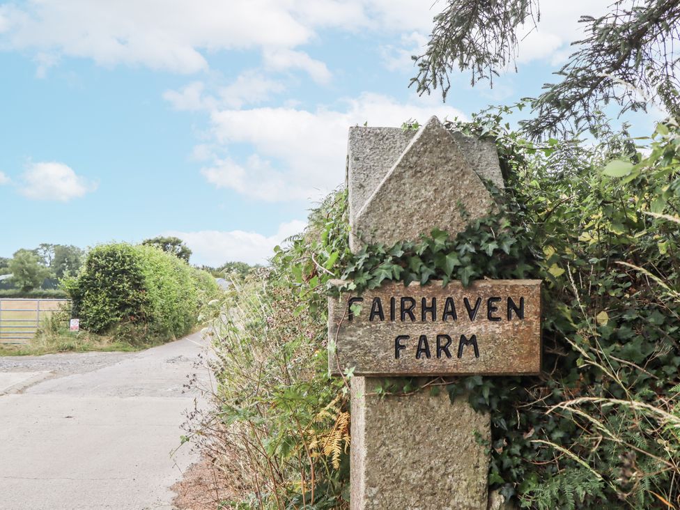 A sign for Fairhaven Farm by the side of a road in Okehampton