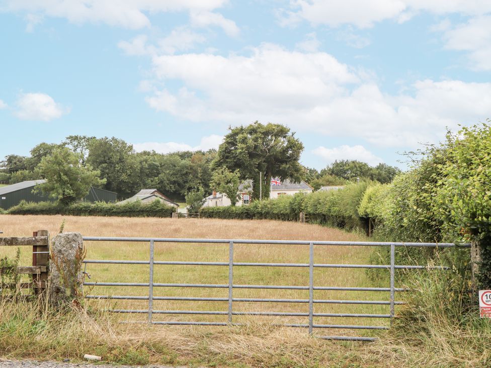 A gate leading to a field with trees and buildings at Aunty Junes Cottage Okehampton