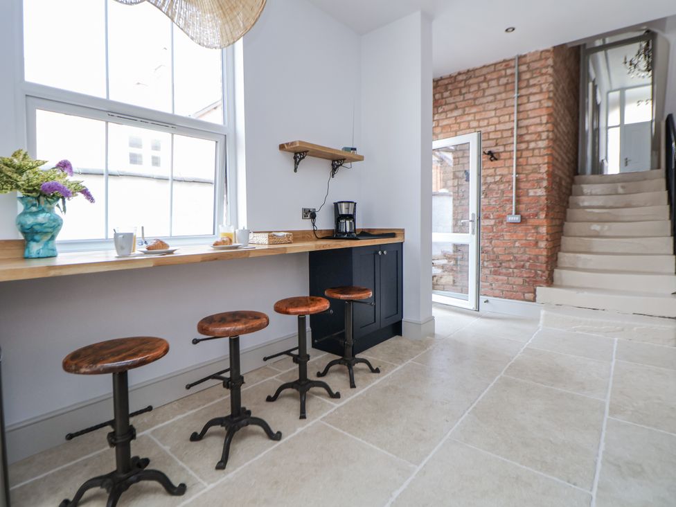 A kitchen with bar stools and a wooden table at 33 Lorne Street Chester