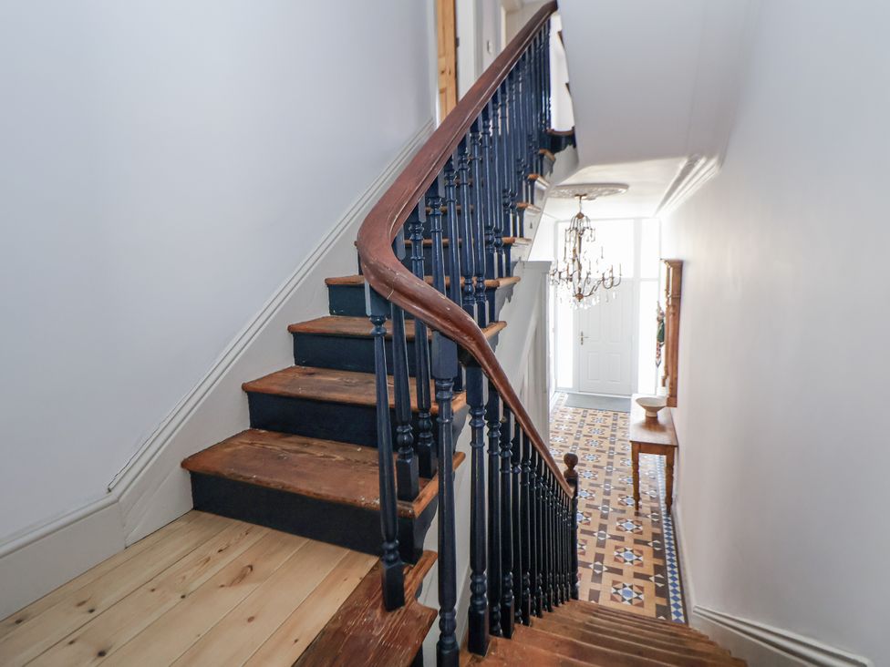 A staircase leading to a front door with a chandelier at 33 Lorne Street Chester
