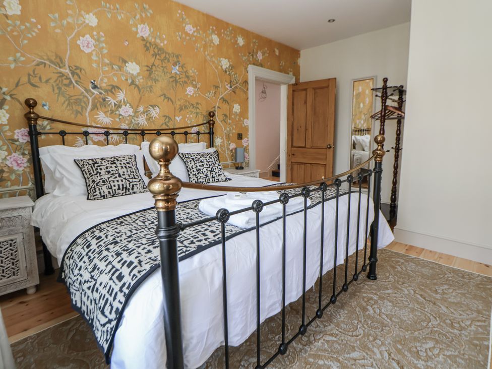 A bedroom with a bed and decorative wallpaper at 33 Lorne Street Chester