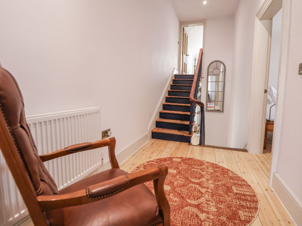 A hallway with stairs and an armchair at 33 Lorne Street Chester