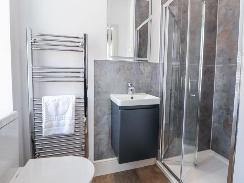 A bathroom featuring a toilet, sink, towel rail, mirror, and shower at 33 Lorne Street Chester